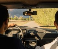 Two new drivers practicing on a scenic road to overcome first-time driving anxiety