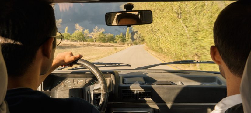Two new drivers practicing on a scenic road to overcome first-time driving anxiety
